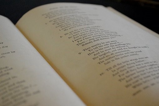 An open poetry book showing verses of a poem